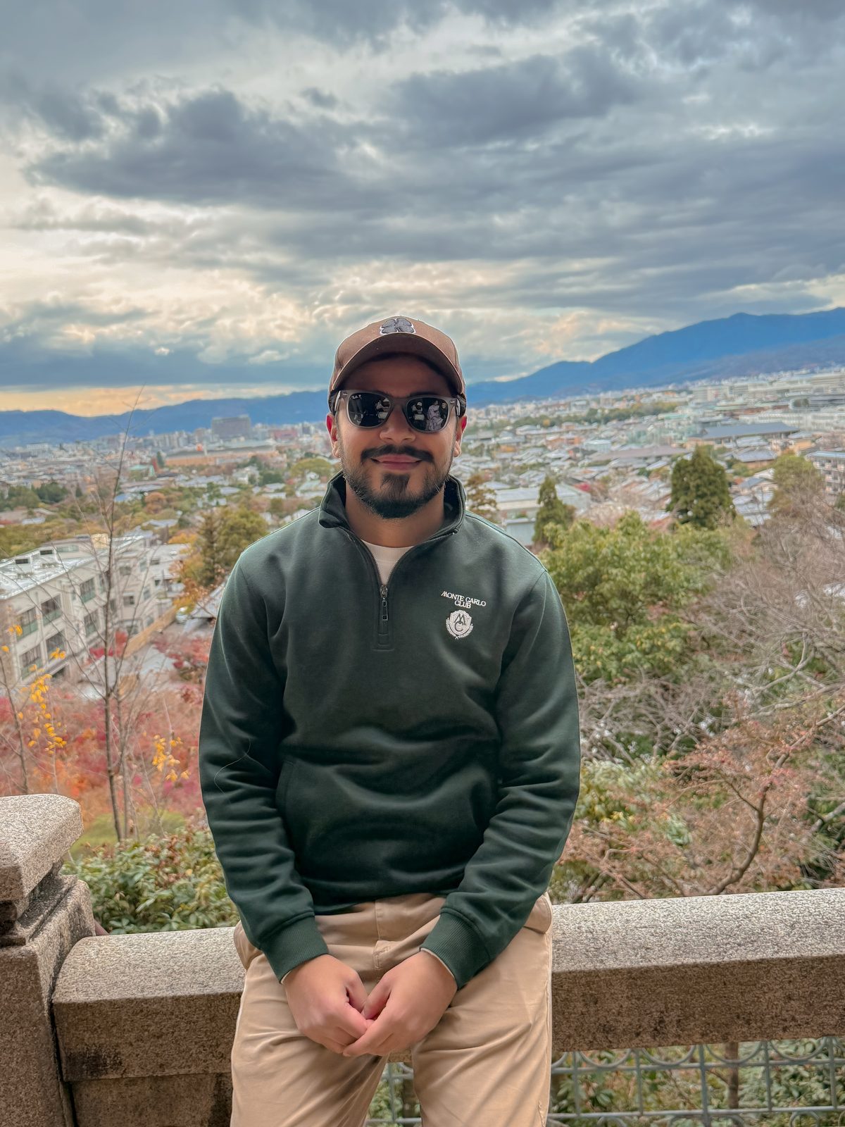 Faiq at a stone overlook above Kyoto in autumn